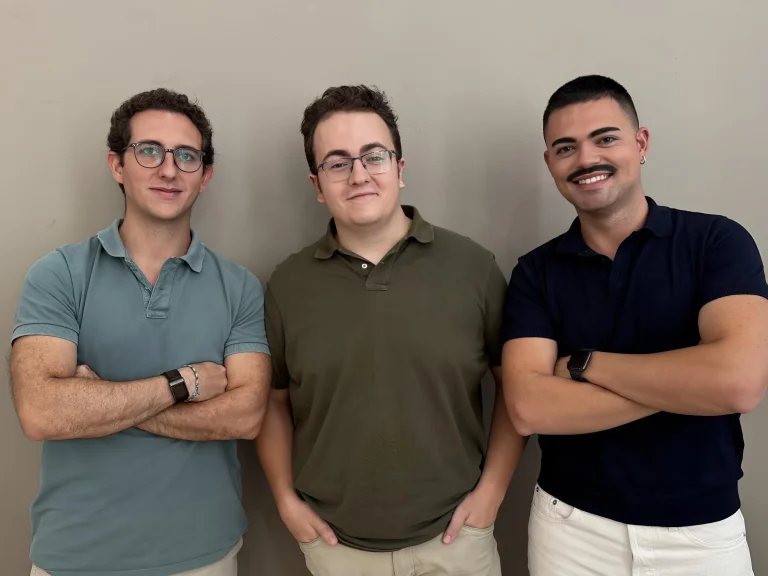 Tres integrantes de Tierra posan juntos, con los brazos cruzados, como equipo de agricultura vertical urbana en Madrid.